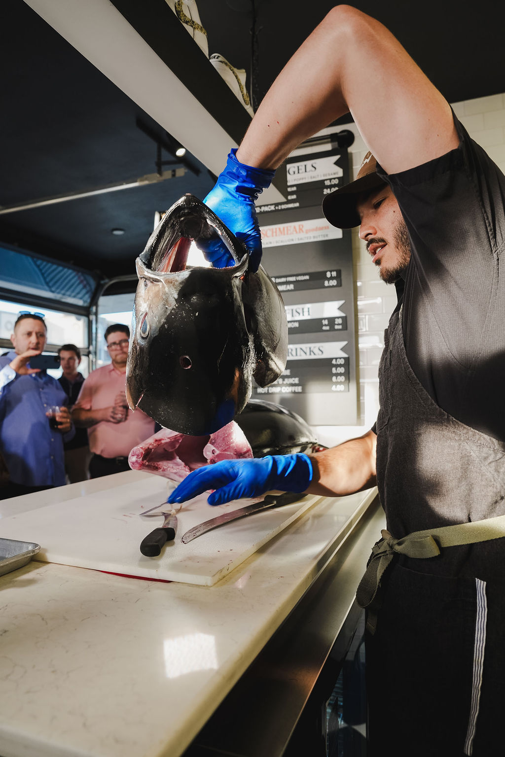 A chef presents a bluefin tuna head to a crowd of guests at an Otoro Club event.