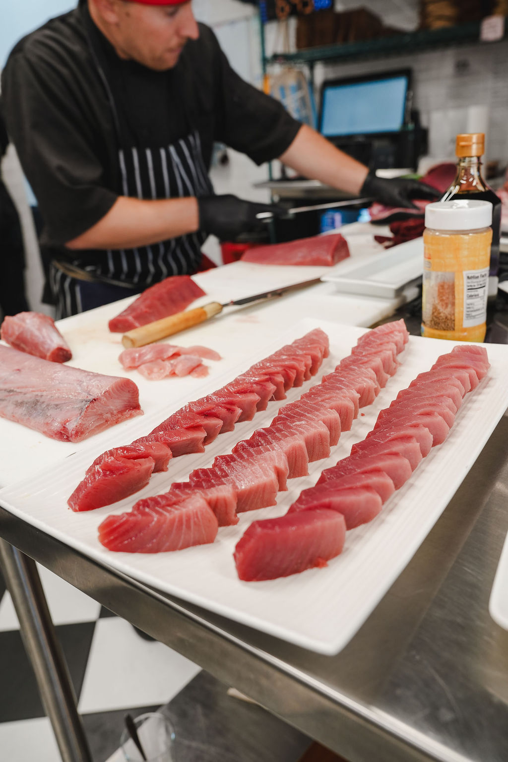 Rows of bluefin sliced and laid out on a board, lean to fat.
