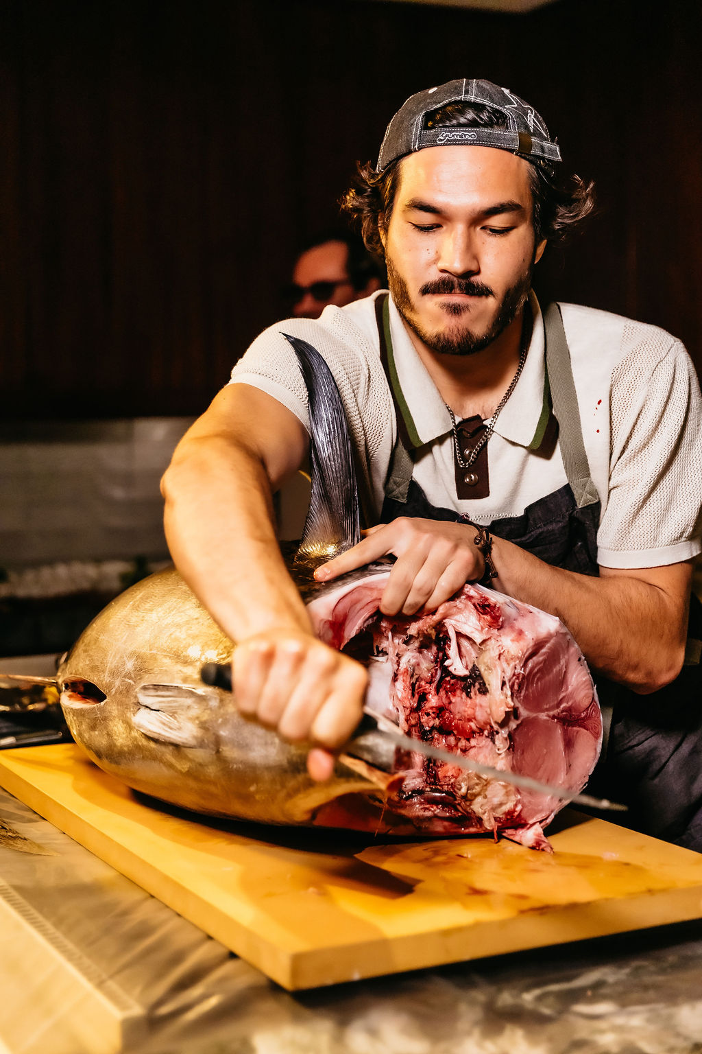A master cutter mid-breakdown on a whole bluefin tuna at an Otoro Club event.